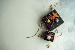 Top view of Christmas gift boxes with holiday decor on stone background with copy space