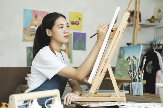 Crafting Inspiration: Female Artist Sketching and Painting in Workshop