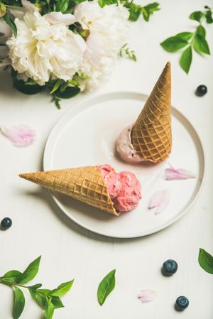Flat lay of ice cream in waffle cones lying on plate