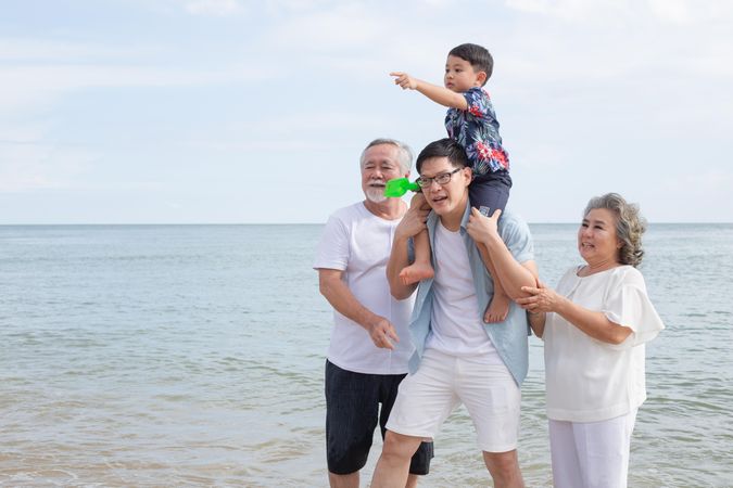 Asian family walking on the beach together