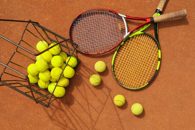 Tennis racquets with tennis balls on clay court