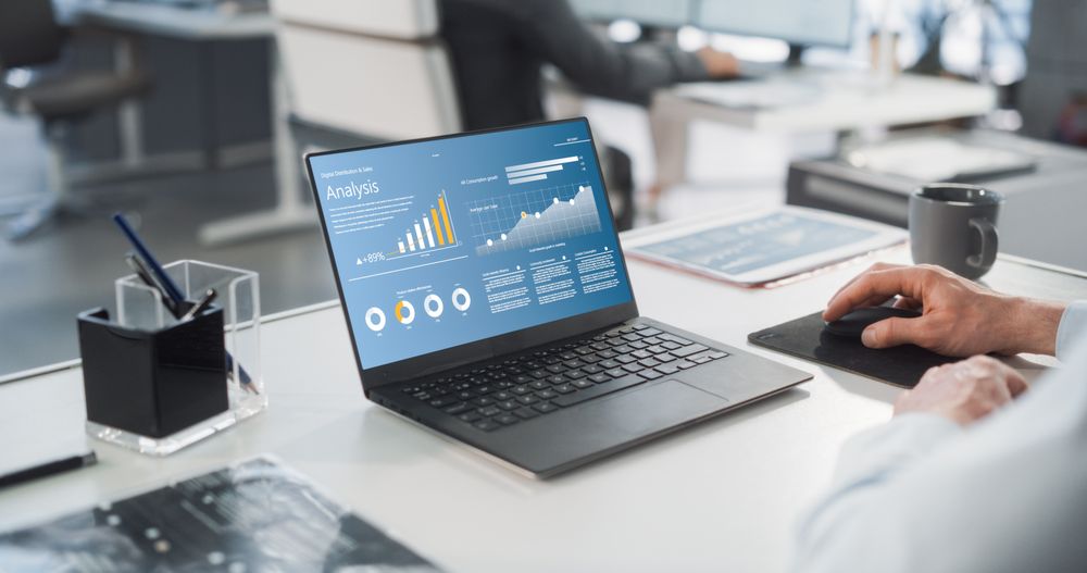 Manager Analyzing Financial Reports, Looking at a Laptop Computer Screen with Graphs and Charts