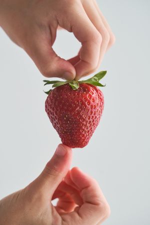 Anonymous person holding appetizing strawberry