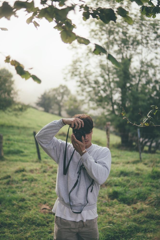 Young photographer shooting with a camera in the woods