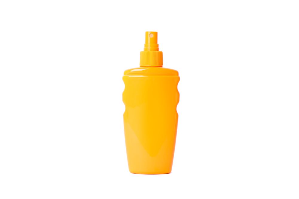 Sunscreen spray isolated on studio background. Summer vacation accessories