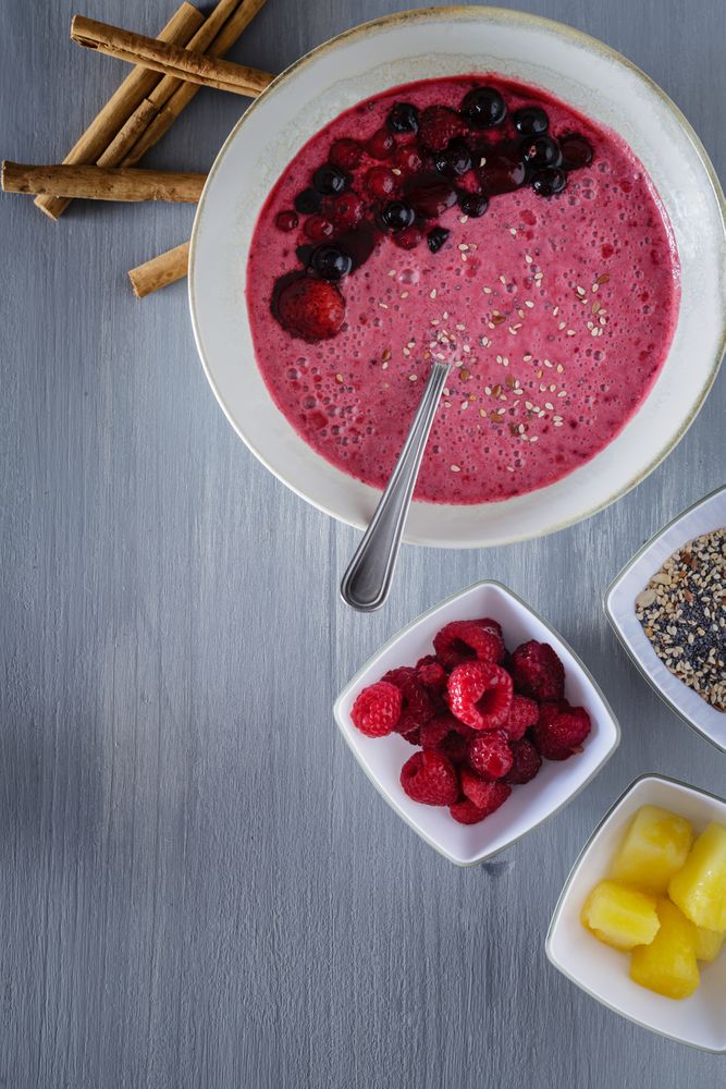 Smoothie bowl with fresh berries and sesame served on table
