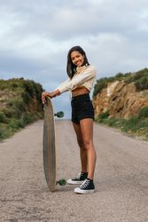 Joyful woman standing with longboard