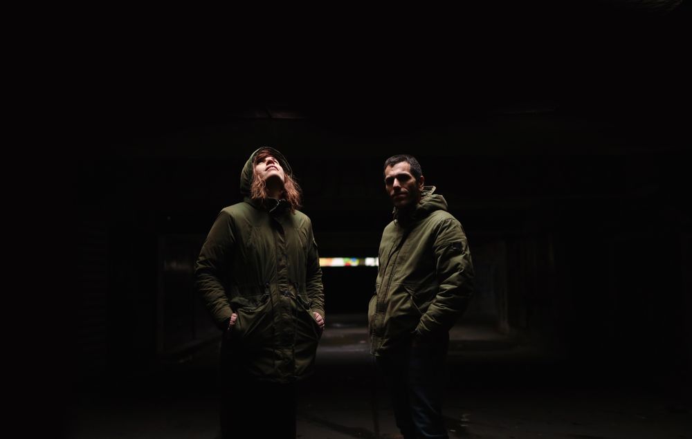 Partners standing alongside each other  under the dramatic light.