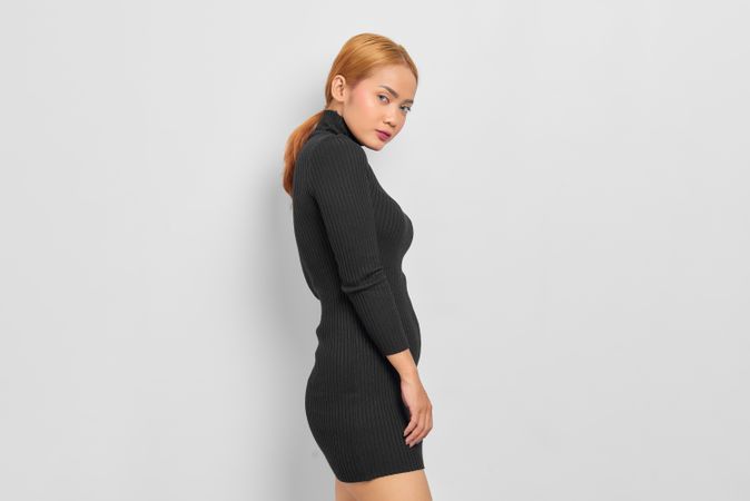 Side view of Asian woman with red hair modeling in studio