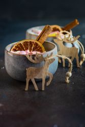 Side view of marshmallow drink in mugs with reindeer ornaments