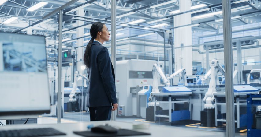 Electronics Manufacturing Technician Working on a Tablet Computer at a Factory Space. Asian Female Specialist Developing, Maintaining, and Fine-Tuning Programs for Machine Production and Assembly