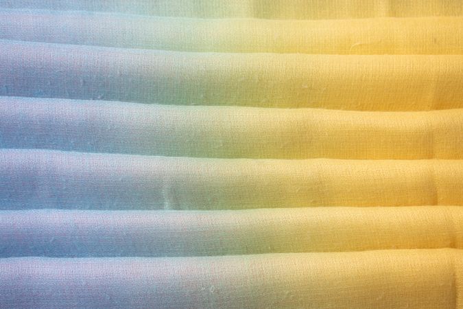 Gradient colorful folded fabric background texture. blue yellow and green.