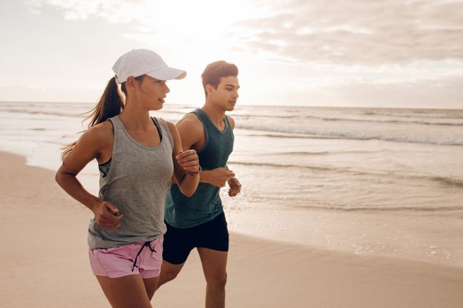 Fitness couple running at beach