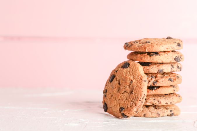 Stack of tasty chocolate chip cookies on wooden background. Space for text