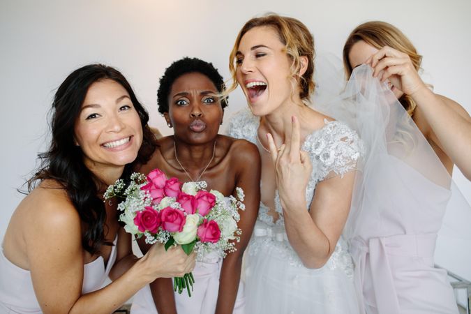 Portrait of cheerful bridesmaids with the bride in the room in the morning