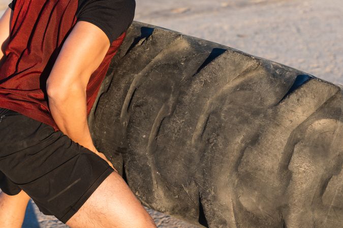 Anonymous strong man doing tire flip exercise