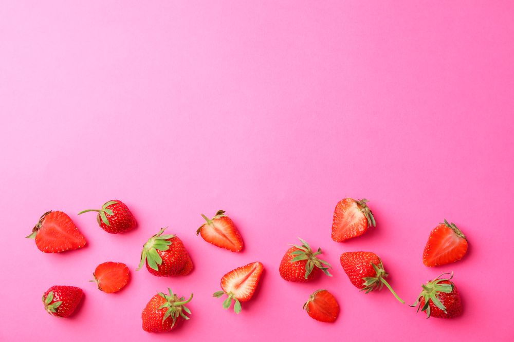 Flat lay composition with strawberries on color background, space for text. Summer sweet fruits and berries