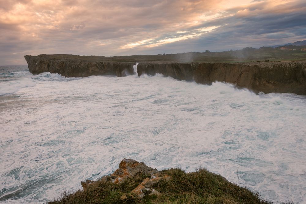 Powerful wave splashing at granite cliff