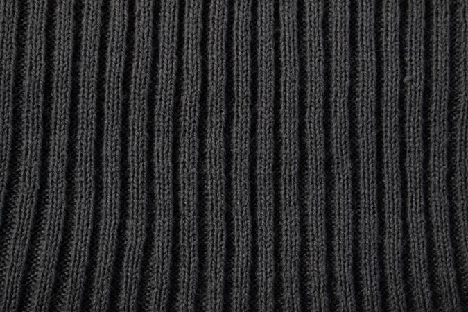 Close up dark grey knitted fabric background texture.