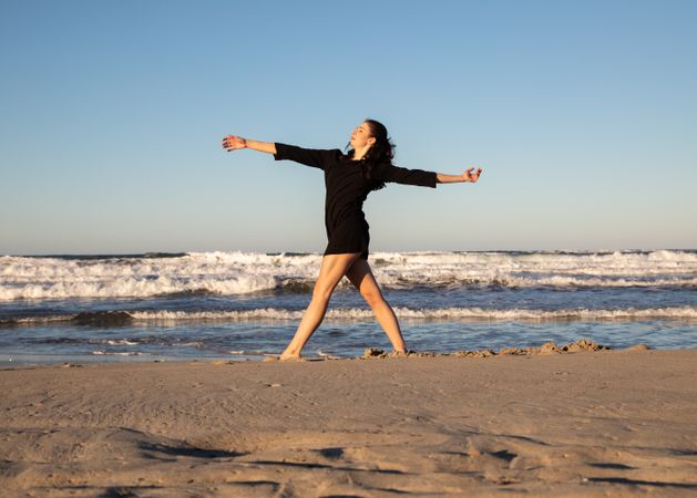 Woman with dancing near water on shore