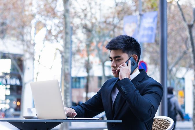 Cheerful Asian businessman working in cafe