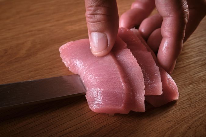 Male hands slicing fresh bluefin tuna loin