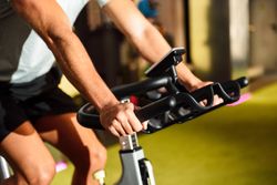 Hands of a male training at a gym doing indoor biking