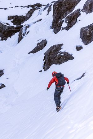 Tourist walking at snowy mountain slope