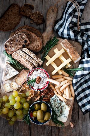 Bred, cheese, olives and grapes on wooden board