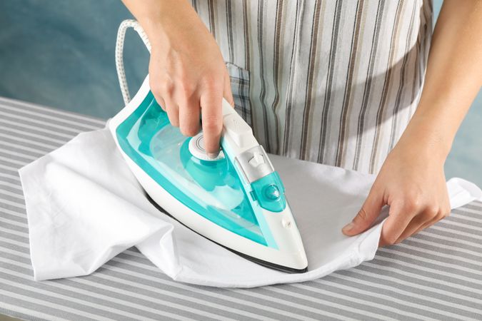 Young woman ironing on board, close up