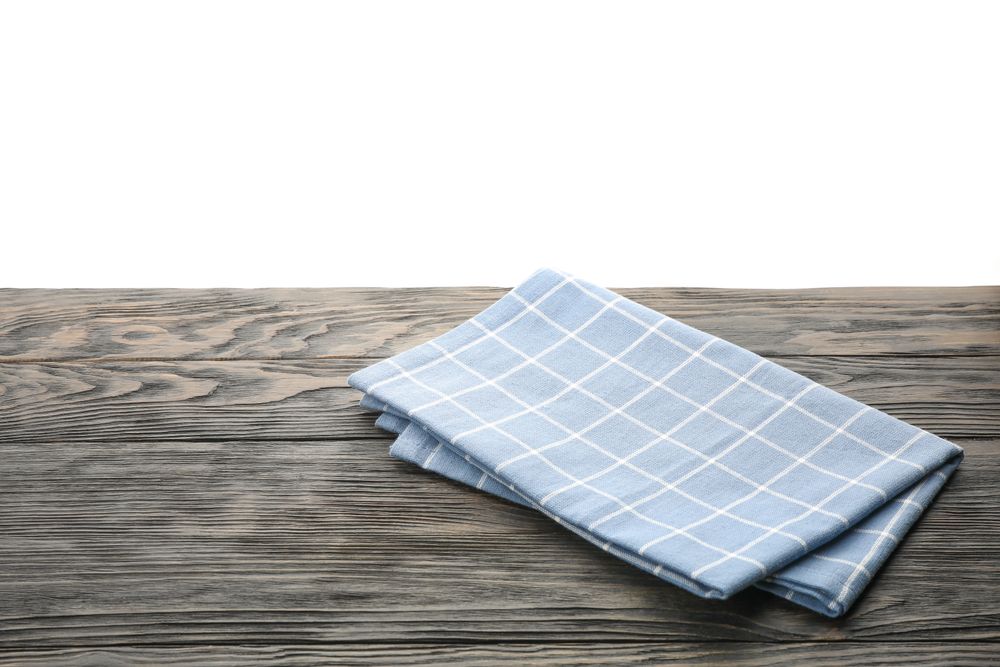 Fabric napkin on table against plain background, space for text