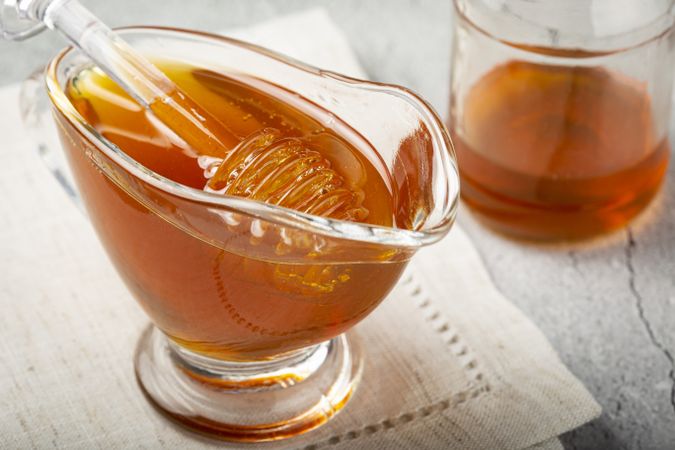 Honey in glass bowl on the table.