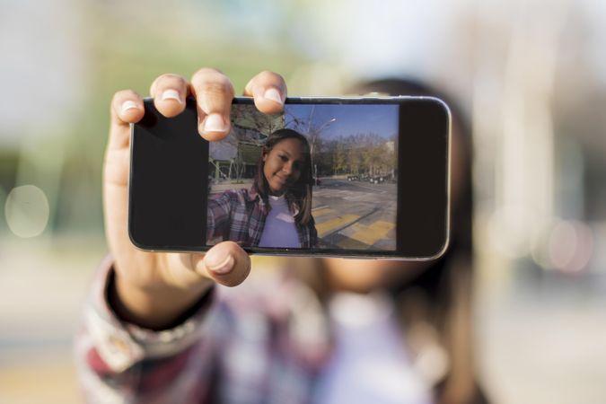 Screen of smartphone with woman taking selfie