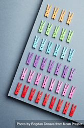 Rainbow colored clothes pins on gray background 43A6V0