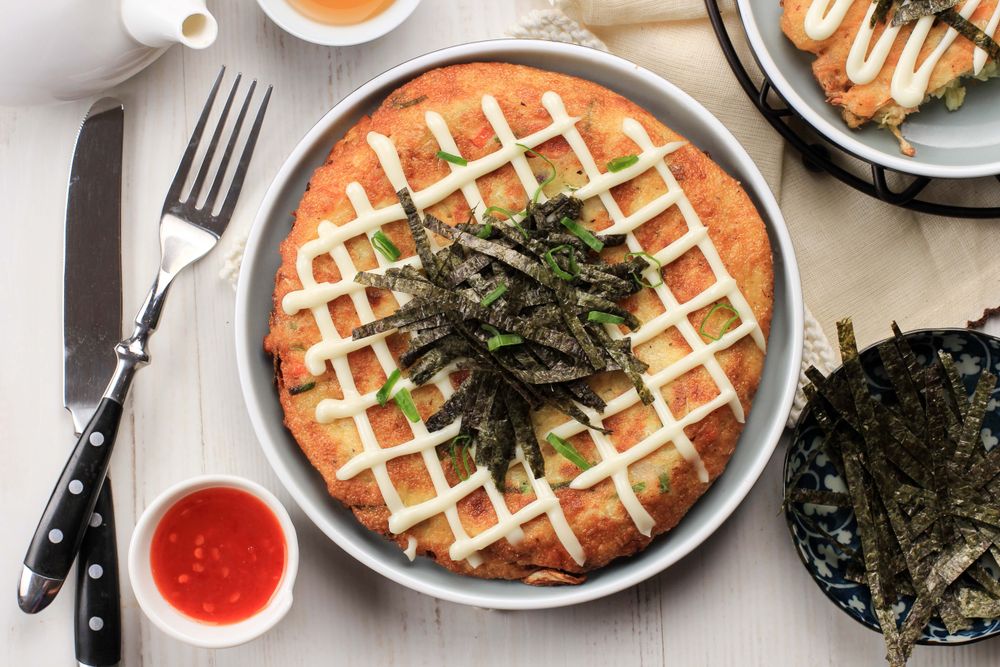 Japanase dish Okonomiyaki, Served on Ceramic Plate with Tea