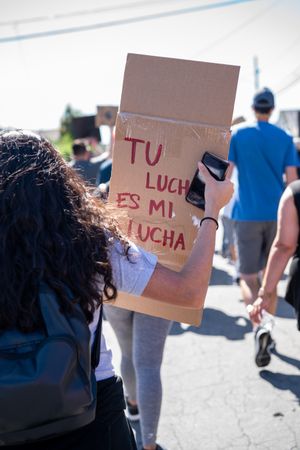 Los Angeles, CA, USA — June 7th, 2020: person holding “Tu lucha es mi lucha” sign at protest