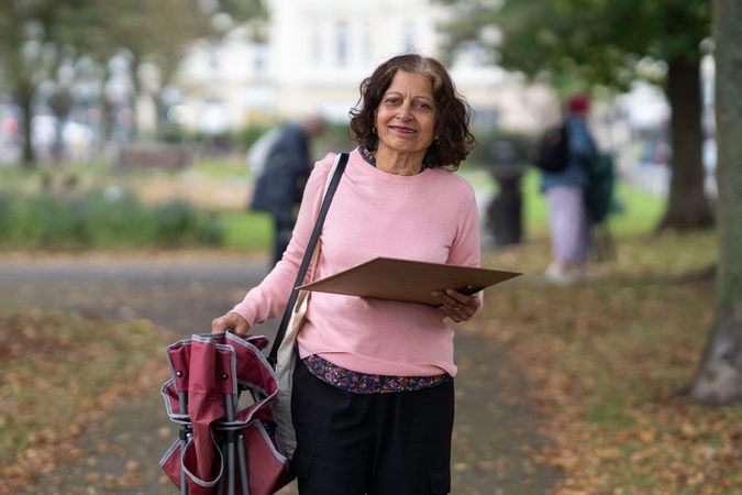 Indian woman leaving park with her art supplies