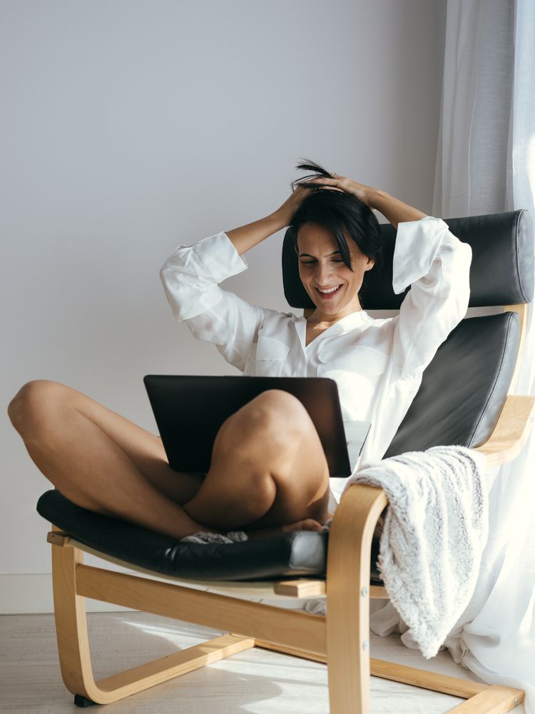 Cheerful woman smiling during video call via netbook