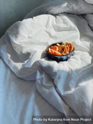Duvet in morning light with bowl of orange slices 4d68A0