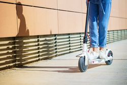 Legs of woman going around the city with an electric scooter