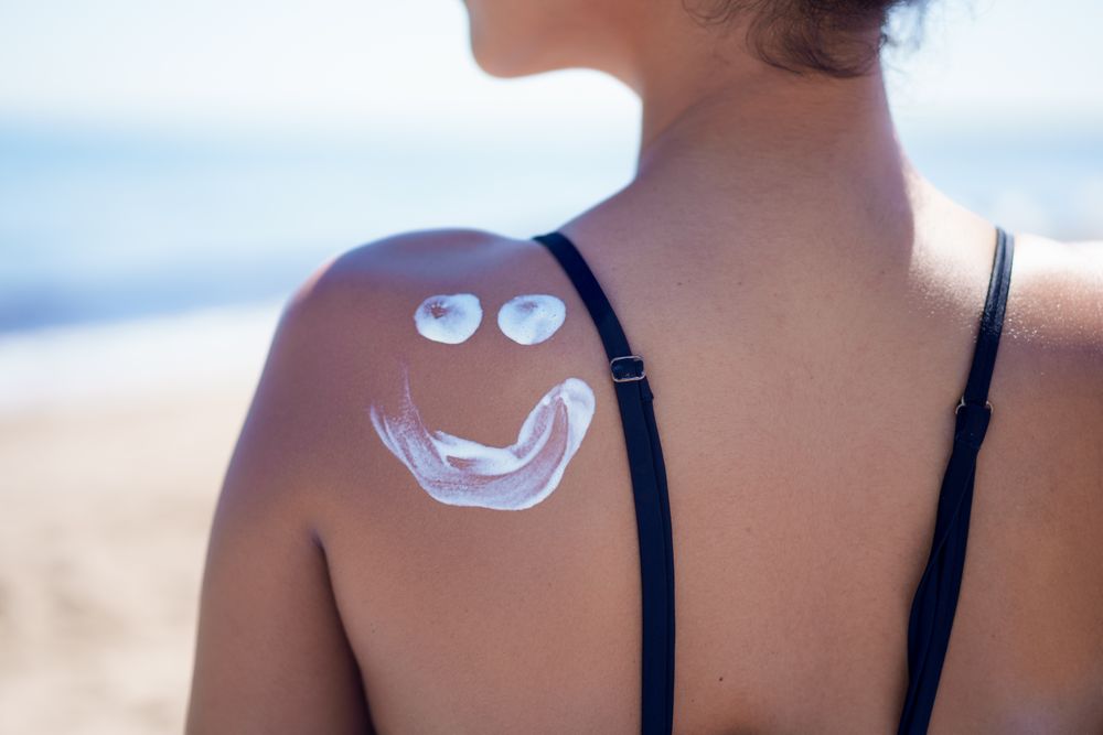 Enjoying a playful Sunscreen application on your face while relaxing on the shoulder at the beach