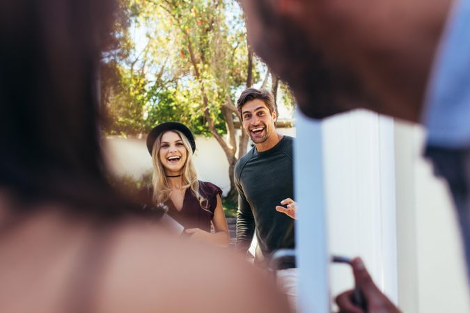 Excited couple at entrance door with wine bottle