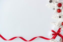 Gift box wrapped with red ribbons, and decorations, on light background