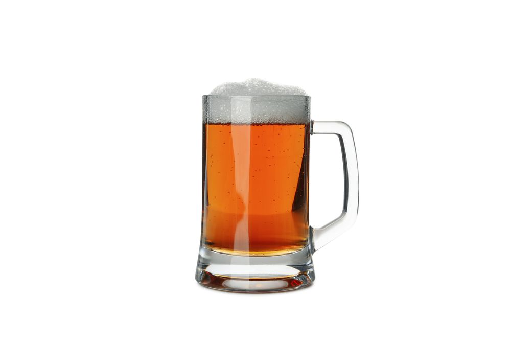 Glass of beer isolated on light background