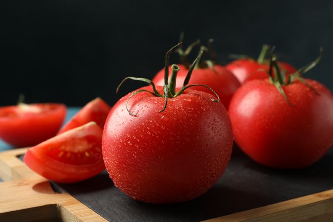 Fresh tomatoes on board on wooden table. Ripe vegetable