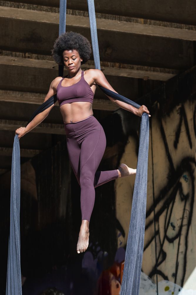 Female doing yoga with aerial silks in city