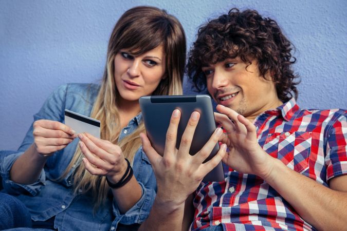 Couple thinking about making an online purchase with tablet