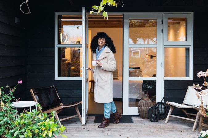 Happy Black woman standing in doorway of house