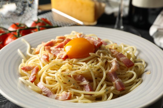 Composition with plate of tasty pasta on wooden background, close up