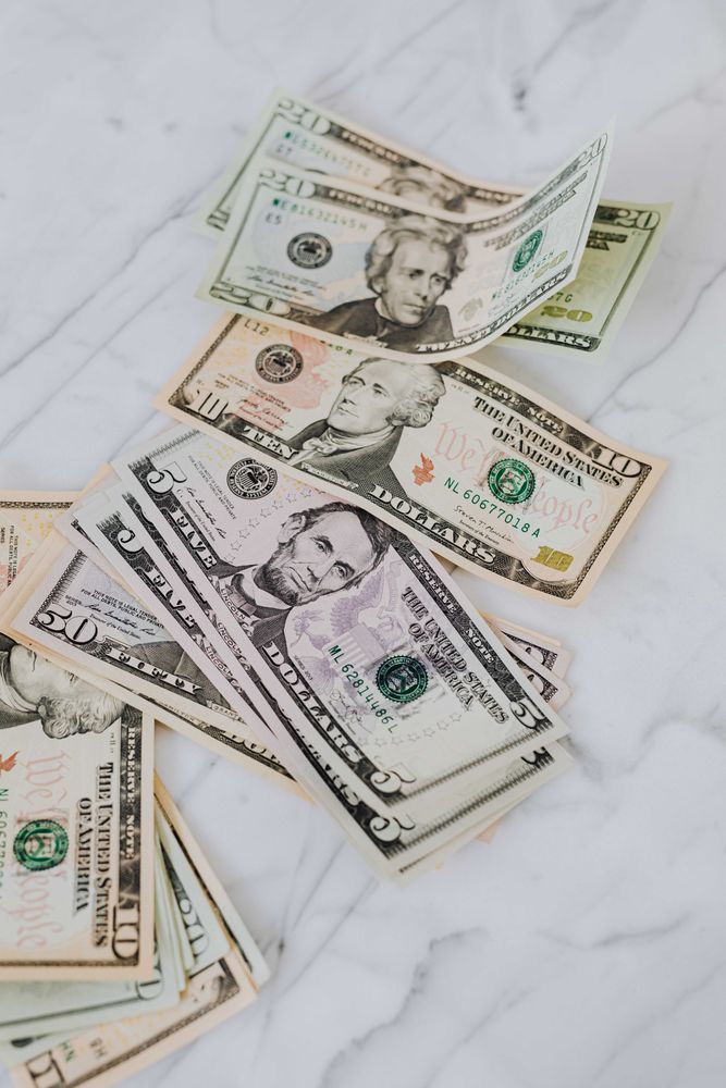 Dollar bills stacked on marble surface